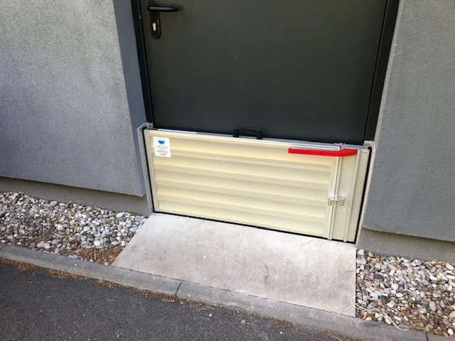 Barrière anti-inondation posée devant une porte-fenêtre en rez-de-chaussée
